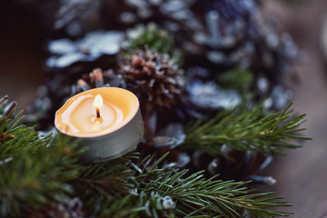 Obraz na płótnie Canvas Advent decoration, wreath, candle. In the dark a candle in a beautiful decorative wreath is burning.