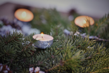 Advent decoration, wreath, candle. In the dark a candle in a beautiful decorative wreath is burning.