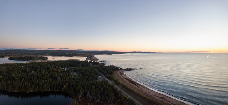 Aerial panoramic view of a Beautiful Sandy Beach on the Atlantic Ocean Coast during a vibrant sunrise. Taken near in Pabos Mills, Quebec, Canada.