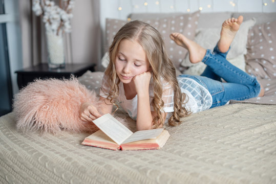 Cute Girl Reading On The Bed