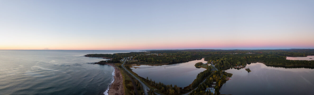 Aerial panoramic view of a Beautiful Sandy Beach on the Atlantic Ocean Coast during a vibrant sunrise. Taken near in Pabos Mills, Quebec, Canada.
