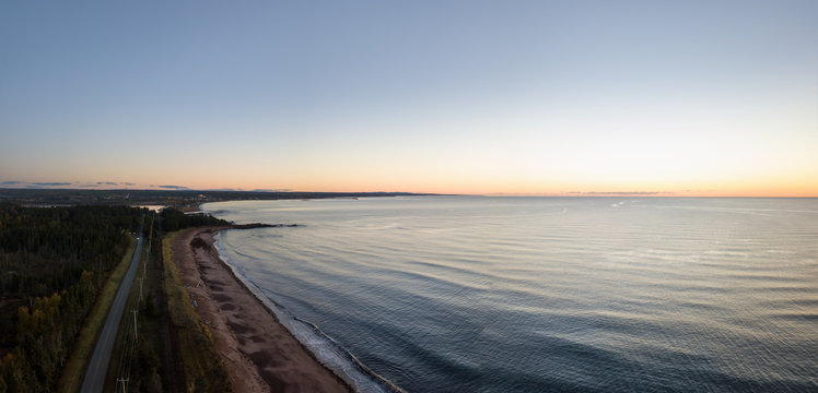 Aerial panoramic view of a Beautiful Sandy Beach on the Atlantic Ocean Coast during a vibrant sunrise. Taken near in Pabos Mills, Quebec, Canada.