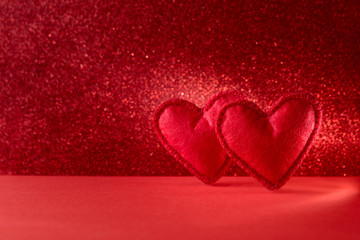 Felt hearts on red background with bokeh. Valentine's day celebration or love concept. Copy space