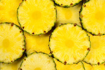 Pineapple juicy yellow slices background. Top view.
