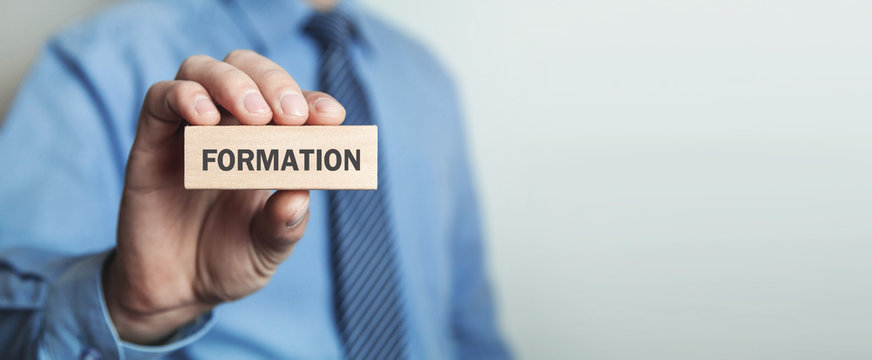 Businessman Showing Formation Word In Wooden Block.