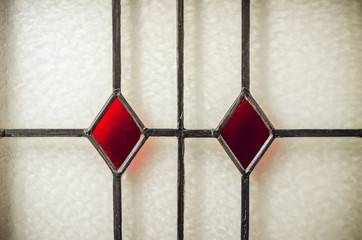 Close-up of leaded stained glass window with red diamond patterns