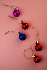 festive multi-colored decorative balls on a pink background.