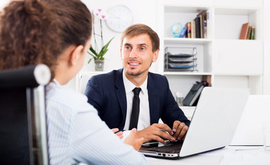 Business male assistant wearing formalwear using laptop