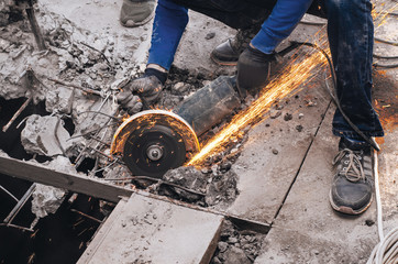 Cutting metal reinforcement in reinforced concrete. Sparks from friction with metal. Disassembly...