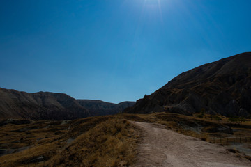 road in mountains against clear blue sky, sunny day