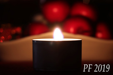 Happy new year 2019 white text on picture with burning candle and fruits in blurr background