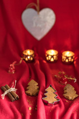 Christams decoration. Homemade Christmas tree shaped gingerbread cookies in the red mood. 