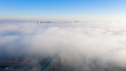 Fototapeta na wymiar Aerial view of the Monument Motherland, shrouded in thick fog at dawn, Kiev, Ukraine. The concept of the apocalyptic doomsday.
