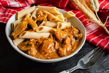 Penne pasta in pork sauce with mushroom.