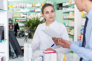 female pharmacist is recommending medicine for man