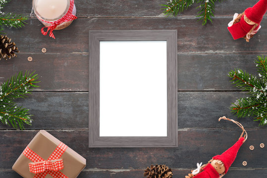 Christmas picture frame for photo or greeting text mockup. Top view scene on wooden table. Gifts and tree beside.