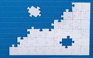Fototapeta premium Fitting last puzzle piece on blue background