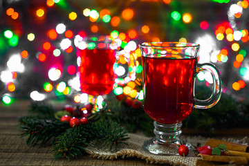 Hot mulled wine on table, magic atmosphere under christmas tree with lights