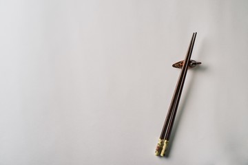 Fototapeta premium Wooden chopsticks with stand, isolated on white background