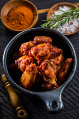 Hot and spicy chicken wings on dark background