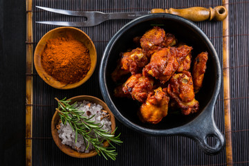 Hot and spicy chicken wings on dark background