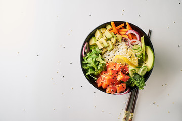 poke bowl with salmon, avocado, cucumber, arugula, broccoli, rice, carrot and sweet onions with...