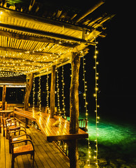 Fototapeta na wymiar light at wooden balcony on the sea at night