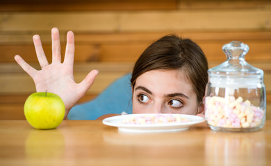 Not confident in her choice. Vitamin or sugar. Woman choose what food to eat. Pretty woman prefer...