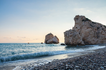 Fototapeta na wymiar Afternoon view of breaking waves at the pebbly beach around Petra tou Romiou, also known as Aphrodite's birthplace, in Paphos, Cyprus.