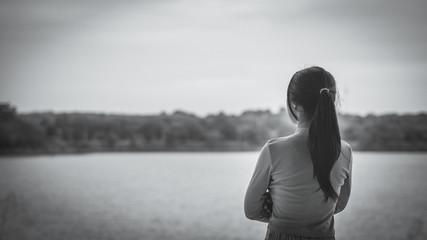 Black and White Lonely woman standing alone beside the river. Lonely, Sadness Concept.