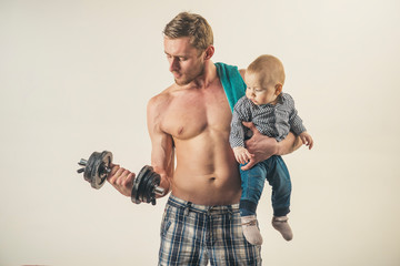Time to sport. Father build biceps triceps with son. Healthy family lifestyle. Strong man with dumbbells hold baby boy. Father and child training together. Active family enjoy sport and fitness