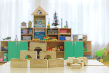 a wooden house from the children's designer on  the background of a children's room full of toys