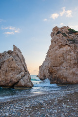 Fototapeta na wymiar Afternoon view of breaking waves at the pebbly beach around Petra tou Romiou, also known as Aphrodite's birthplace, in Paphos, Cyprus.