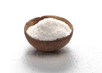 Pile of shredded coconut meat in coconut shell isolated on white background