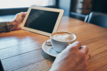 Close up hands man using tablet, connecting wifi. Working just from cafe. Black screen