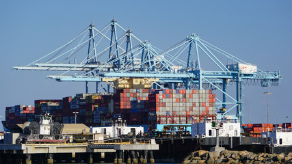 Container ship in a modern industrial shipping harbor operation in the Port of Los Angeles by a row...
