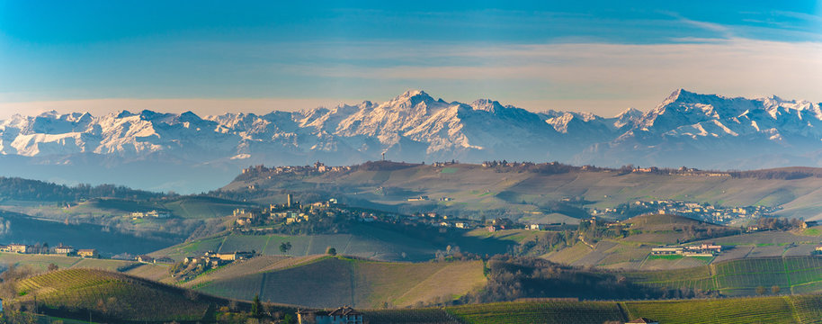Autumnal hills and vineyards in Langhe Monferrato region with mountains on background in Piedmont, Northern Italy.