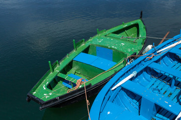 Fototapeta na wymiar Two blue and green boats anchored in a fishing port 