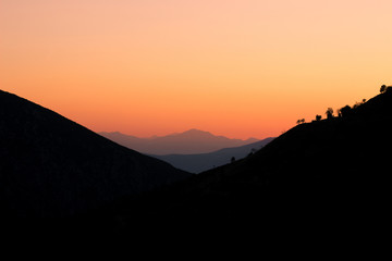 idyllic beautiful landscape of sunset between mountains highland space with clear orange sky, wallpaper pattern and copy space