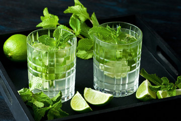 Mojito cocktail with lime and mint on  black background.