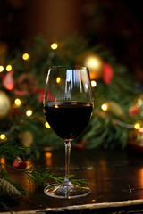 red wine in a glass on the background of garlands, Christmas trees and decorations. Christmas