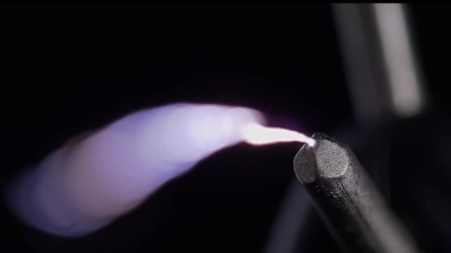 EXTREME CLOSE UP OF A CONTACT ON A STUN GUN.  4K, 10 BIT, 4:2:2.  ELECTRICITY ARCING TOWARDS CAMERA.