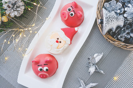 Marzipan in the shape of the symbol of the new year pink - pig, sweet delicate macaroons, marshmallows, peanuts in sugar pastel colors on a light background