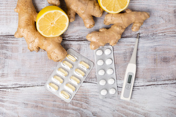 Top view. Healthy concept. Tea, lemon, thermometer, ginger root and tablets on a white background. Flat lay.