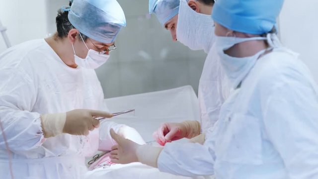 Group of professional surgeon performing important operation on abdominal ulcer to patient
