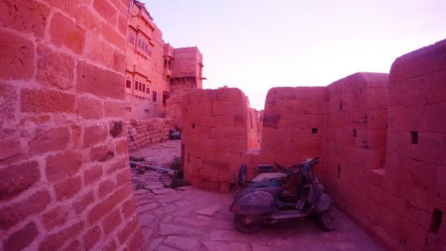 Battlement haveli traditional townhouse old motobike with dust ancient fort sandstone walls predown light
