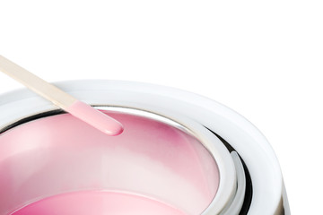 Wax heater with hot pink wax and a spatula