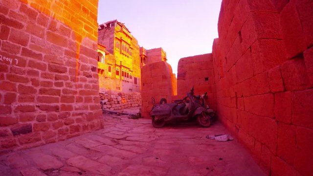 Battlement haveli traditional townhouse old motobike with dust ancient fort sandstone walls light of sunrise