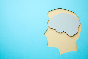 Silhouette of man and a brain inside head on blue background. Copy space for text.