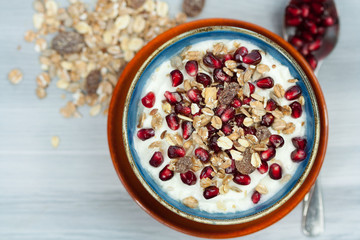 Bowl of greek yogurt with pomegranate and muesli.
